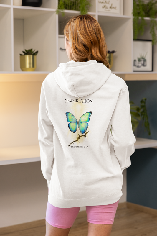 women wearing Christian hoodie featuring a blue and green butterfly rising above a cracked rock, symbolizing transformation and renewal. The design includes the words 'NEW CREATION' at the top and '2 Corinthians 5:17' at the bottom, representing the Bible verse about becoming a new creation in Christ.